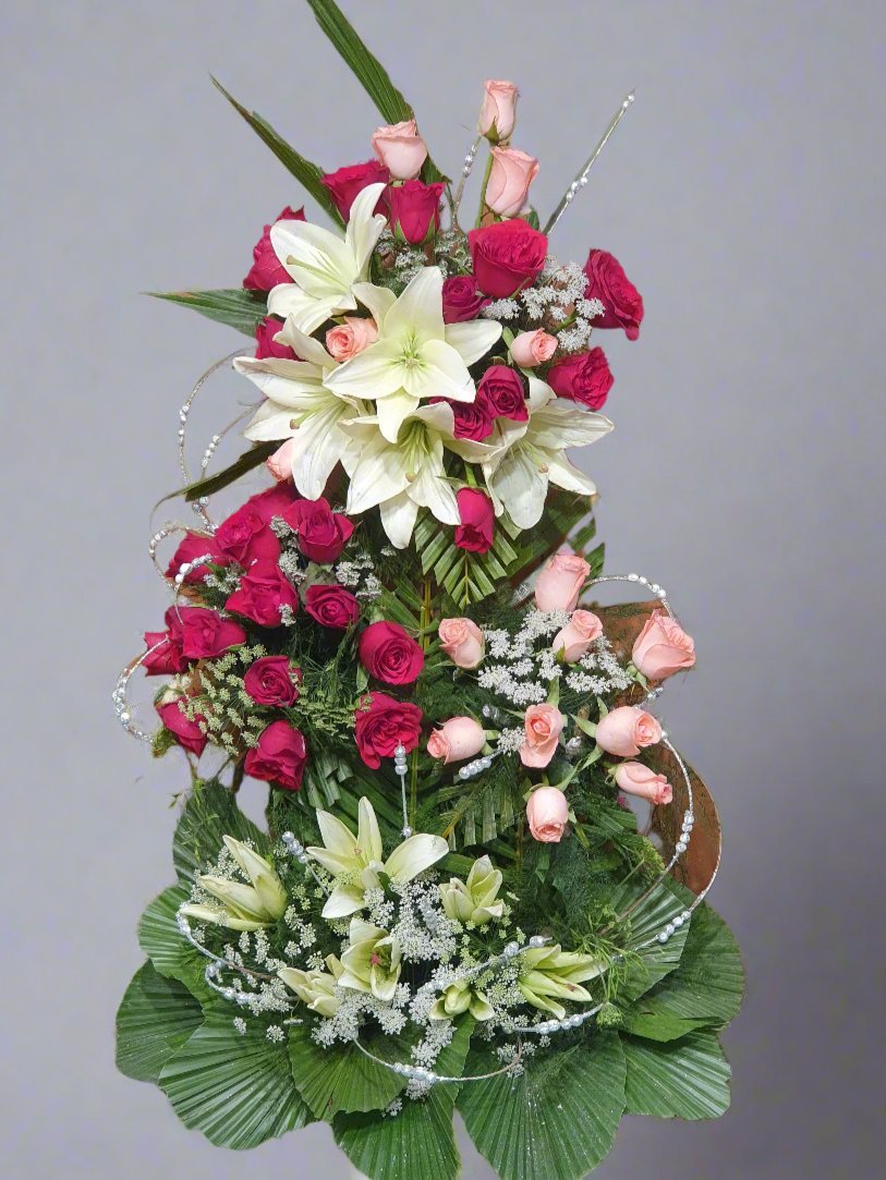 Romantic blend of red roses, pink roses, and white lilies with lush greenery, perfect for any occasion. Fresh, elegant, and visually stunning flowers