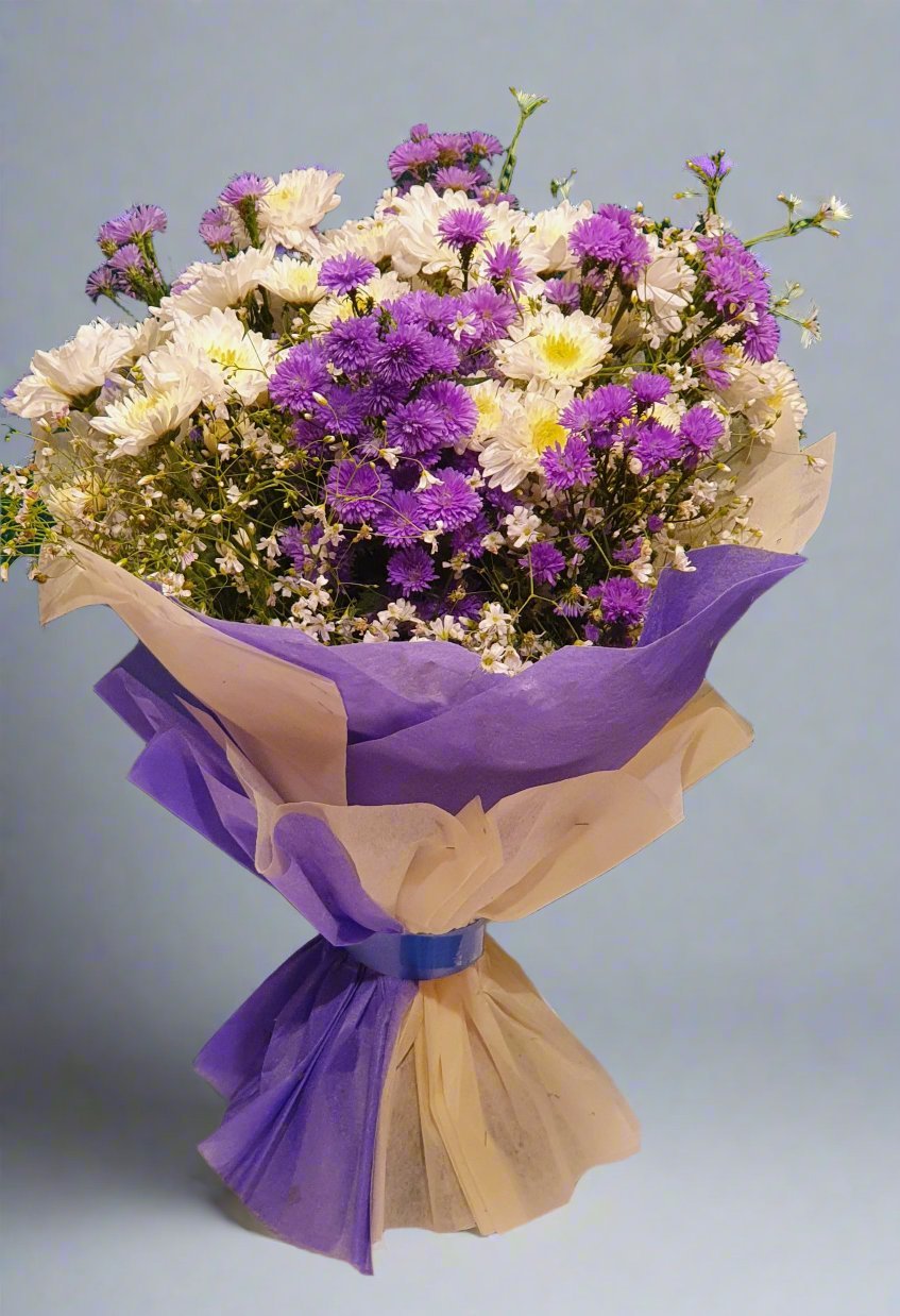 Beautiful arrangement of purple and white daisies with delicate fillers, adding texture and contrast for a stunning floral display.