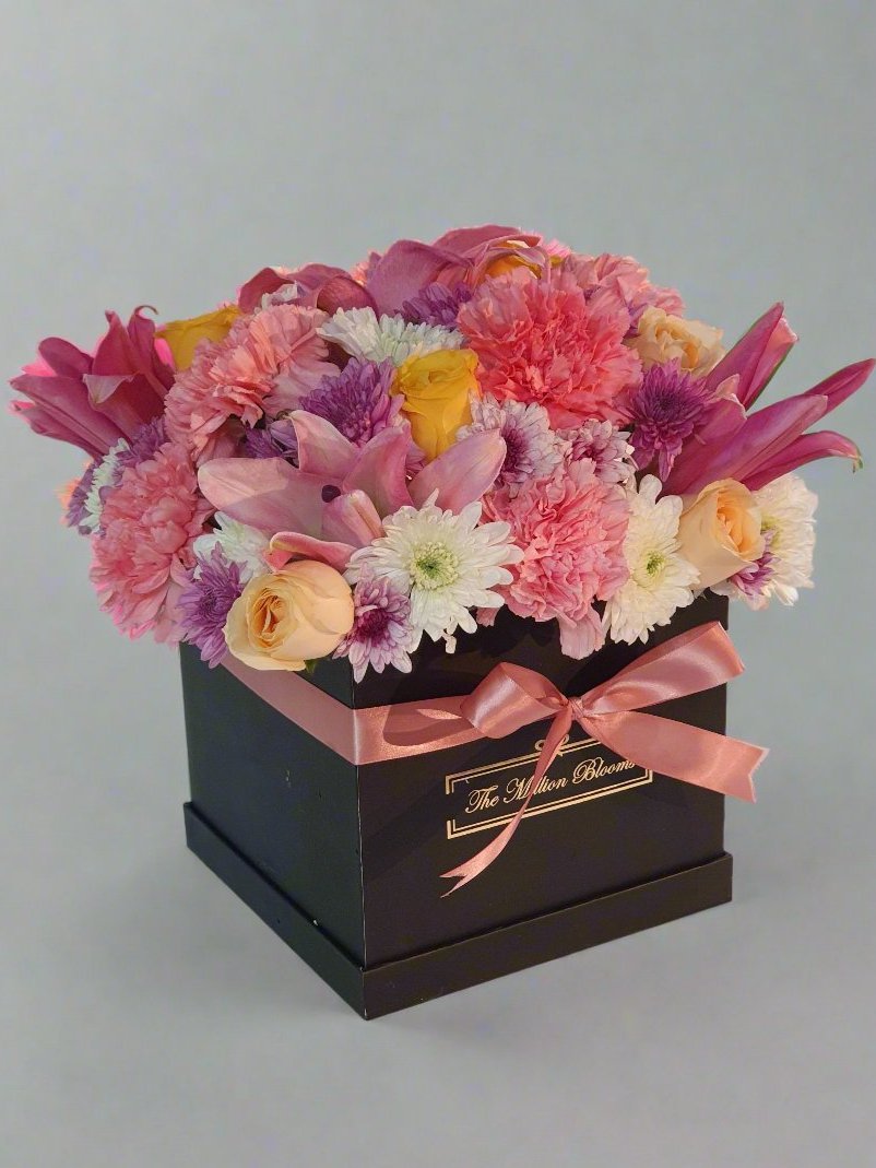 "Vibrant mixed flower box with elegant lilies, charming carnations, classic roses, and seasonal blooms. Perfect gift for any occasion!"