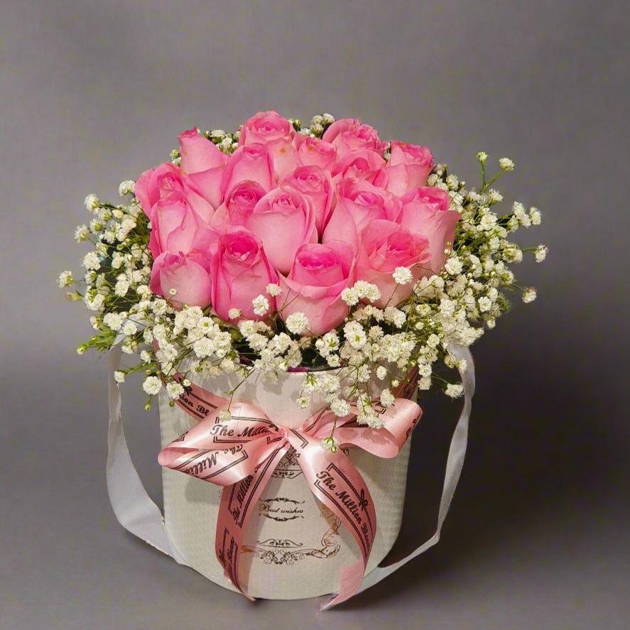 Elegant pink roses with white fillers in a creamy brown box, perfect for any occasion. A sophisticated blend of romance and charm in a single gift.