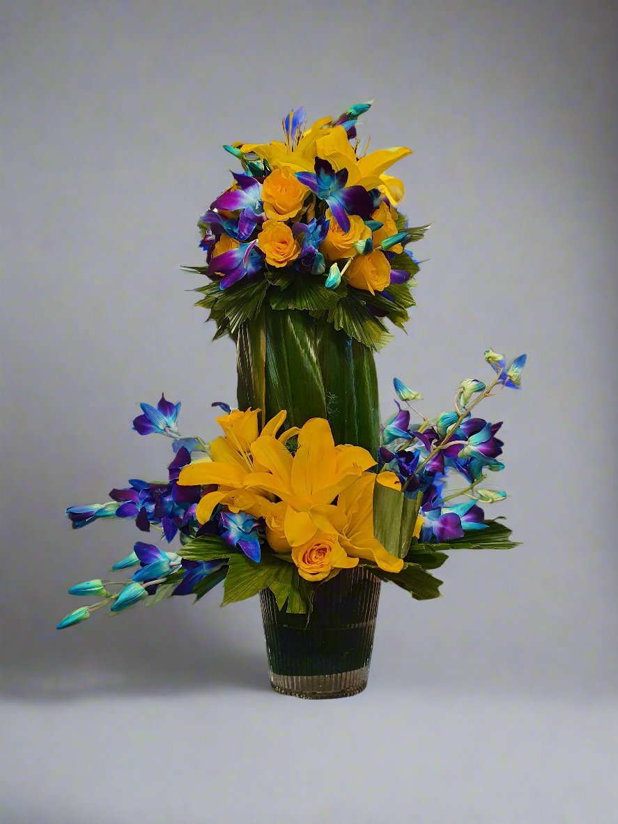 Discover a vibrant floral arrangement featuring yellow roses, yellow lilies, and blue orchids for a stunning, colorful display. Perfect for any occasion.