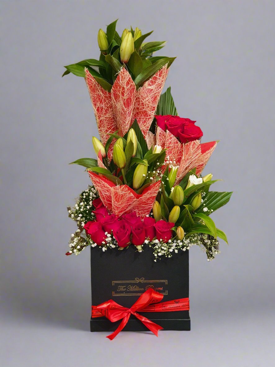 Discover the elegance of red roses paired with lilies, beautifully arranged in a black box. Perfect for any occasion!