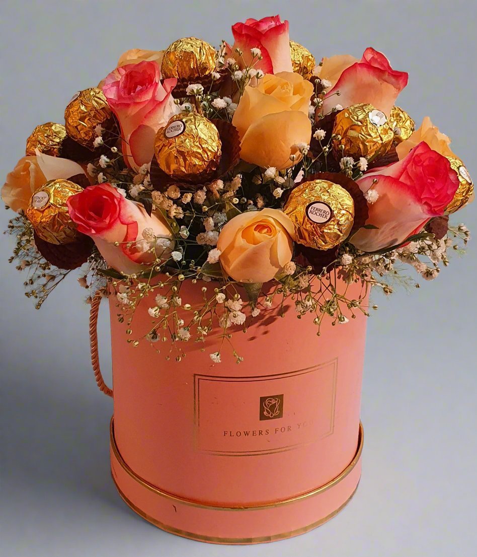 A beautiful pink box with pink-yellow roses, featuring vibrant flowers and creamy ferrero rocher chocolates. The perfect gift for any occasion, combining charm and sweetness.