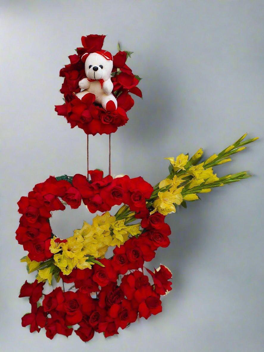 Heart-shaped design with red roses, yellow gladiolus, and a cute white teddy bear. Perfect for expressing love and affection in any occasion.