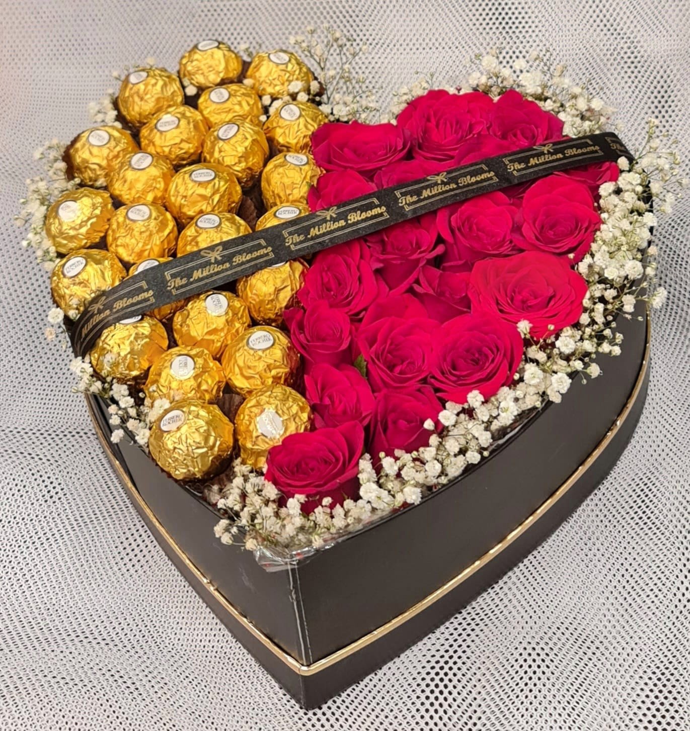 Gift love and elegance with a black heart box filled with red roses, white fillers, and Ferrero Rocher chocolates. Perfect for any special occasion!