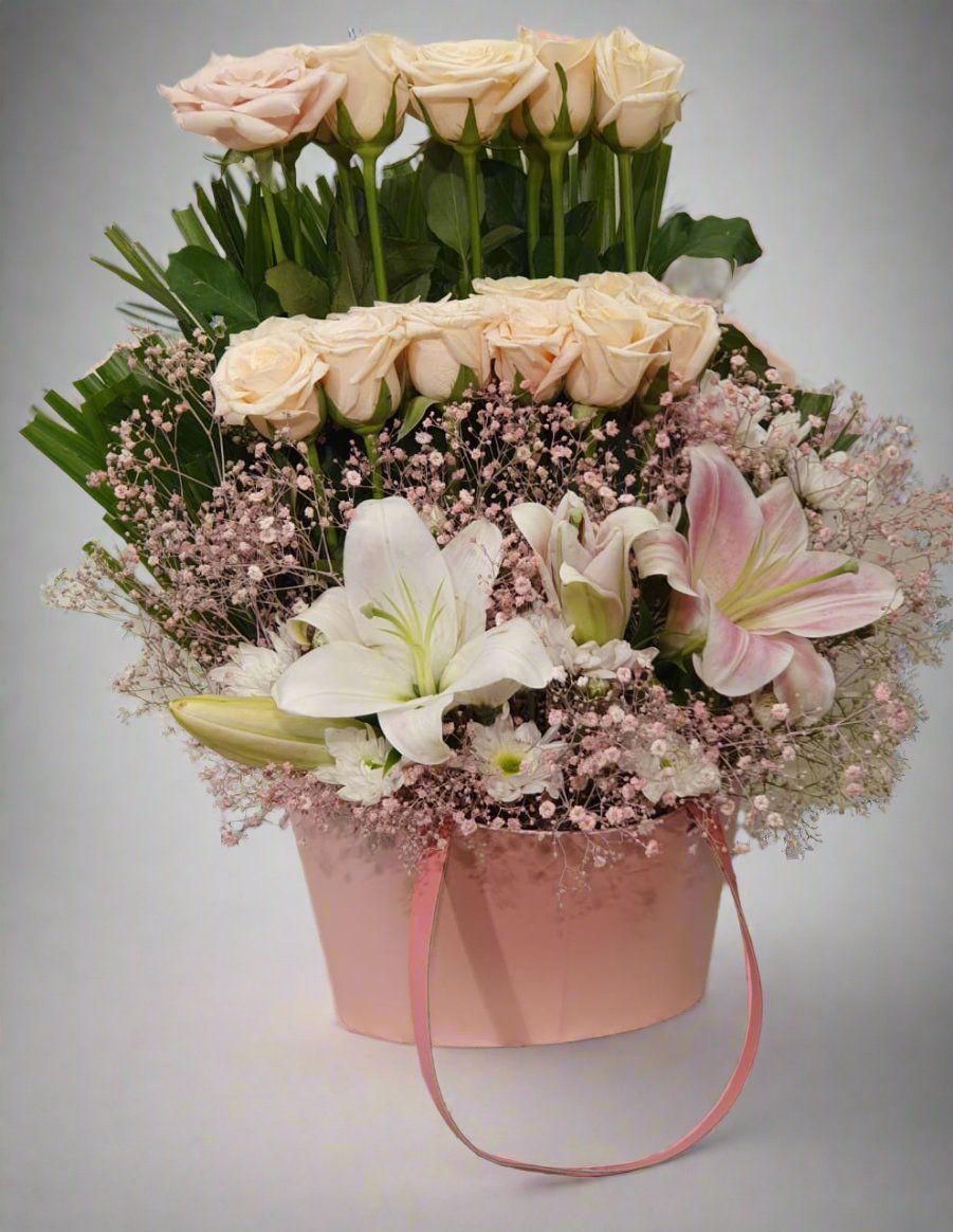 Elegant white and pink lilies paired with vibrant peach roses create a cheerful, timeless floral arrangement, perfect for any occasion.