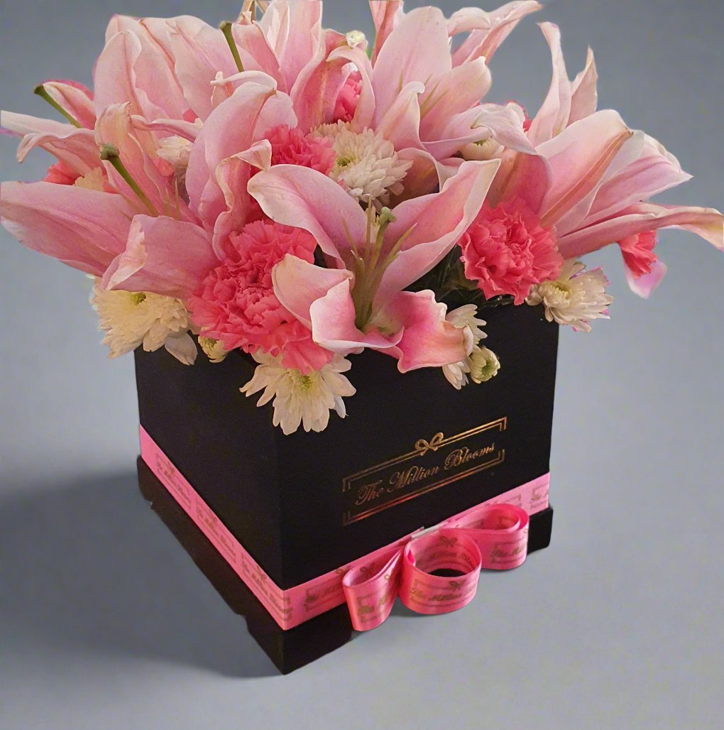 Add elegance to any occasion with our exquisite arrangement of soft pink lilies, pink carnations, and a beautiful white daisy. Perfect for any event.