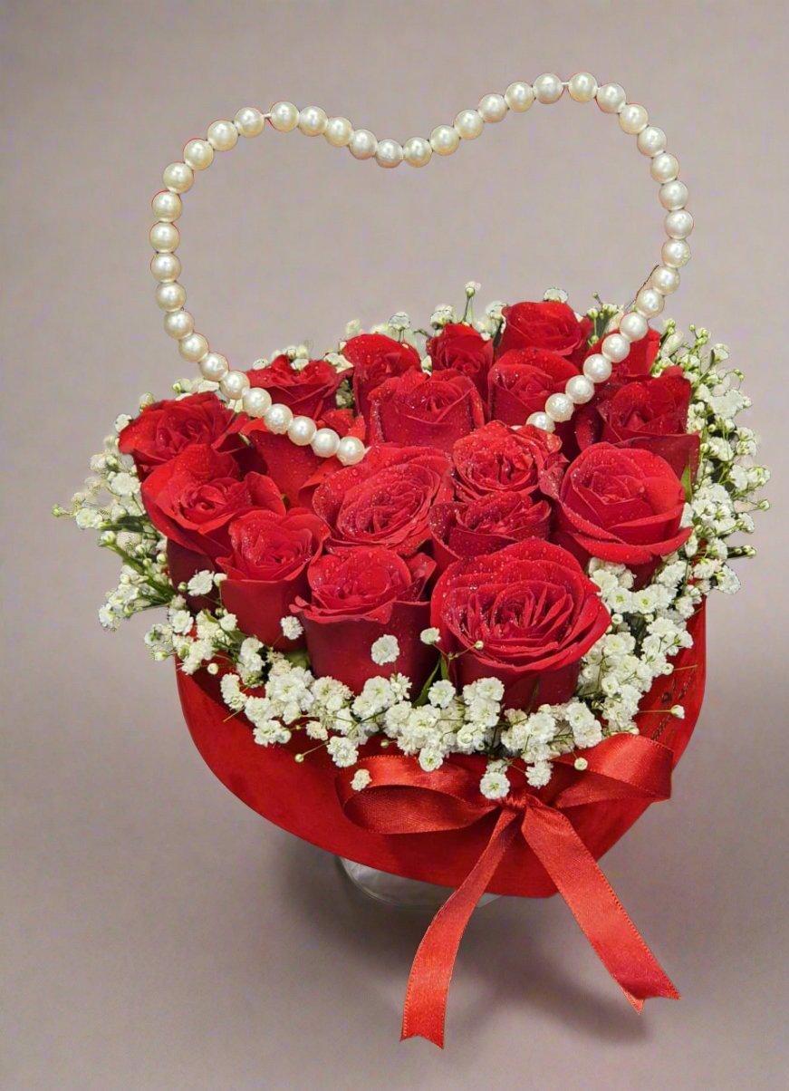 Gift a stunning arrangement of red roses and a pearl heart to express love and elegance. Perfect for romantic occasions and special moments.